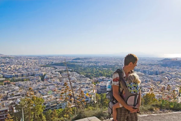 Mężczyzna Córką Plecaku Patrzy Miasto Ateny Góry Słońcu — Zdjęcie stockowe