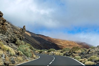 Tenerife adasındaki Teide volkanı yakınlarındaki dağların üzerinden bulutlar, bulutlar, İspanya, doğal arka plan.
