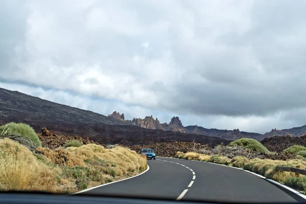 road to foggy clouds on the track to the Teide volcano in Tenerife with a car window, natural background