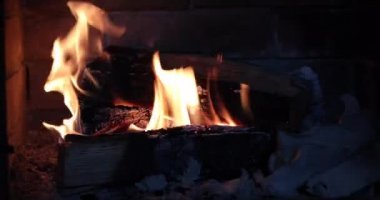 Yakıcı ateşin bulunduğu açık şömineye odun at.