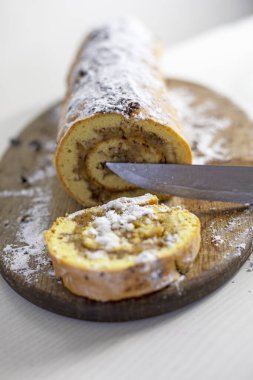 Yeni pişmiş elmalı turtayı bir masanın üzerindeki kesme tahtasıyla kes, dikey.