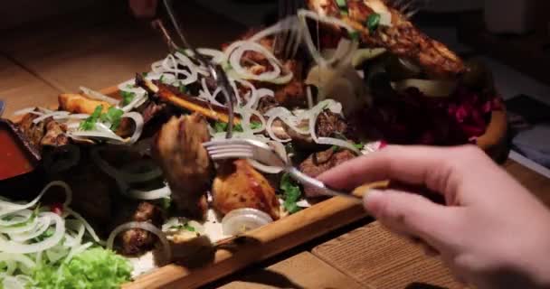 お祝いのテーブルの上にフォークでサラダとソースと混合肉のパンクフォーク — ストック動画