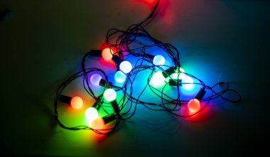 Koyu arkaplanda kalp şeklinde çok renkli çelenkler, romantizm