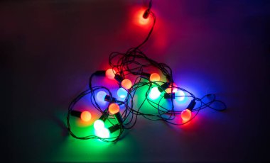 Koyu arkaplanda kalp şeklinde çok renkli çelenkler, romantizm