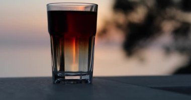 Gün batımında tezgahta taze karbonatlı içecek, kilit altında.