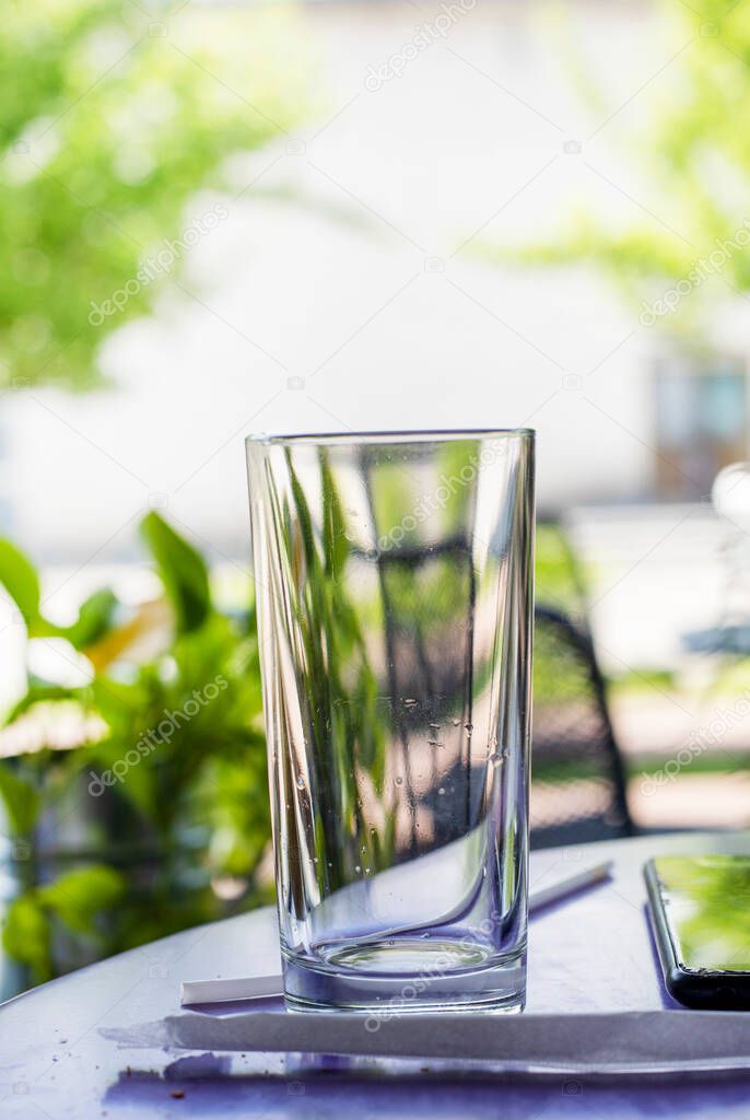 glass empty glass stands on the table outside, vertica