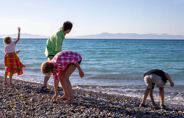 Feliz Papá Muestra Los Niños Cómo Tirar Piedras Mar Vacaciones — Foto de Stock