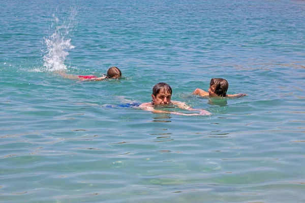 透明度の高い海で泳いでいる女の子と男の子を持つ幸せなお父さんトップビュー水平方向 — ストック写真