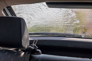 Şiddetli bir sağanakta arabanın bulanık arka camından bak.