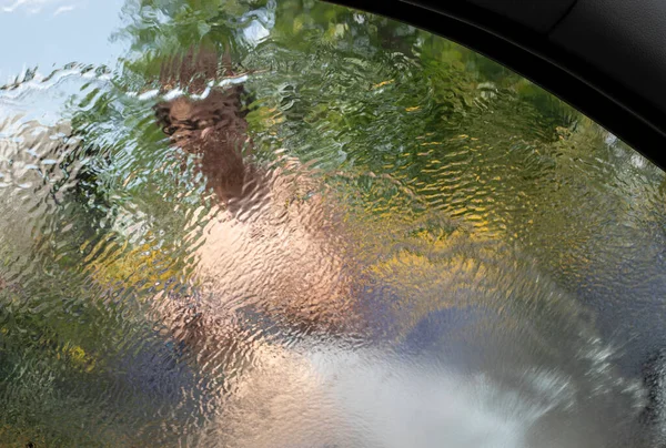 look through the blurred rear windshield of a car at a heavy downpour, flood