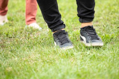 Sabah erkenden çimenlerin üzerinde spor ayakkabılarla yürümek, günaydın, horizonta