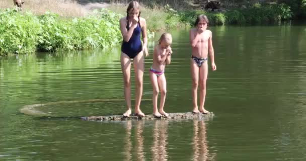 Теплый День Трое Малышей Разных Стилях Прыгают Воду Моста Реке — стоковое видео