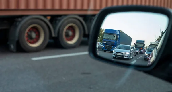 Bir arabanın yan aynasında akşam trafiği sıkışık, yol tamiri sırasında, trafik yoğunluğu şehir caddesinde.
