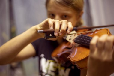 Kibar genç kemancı yatay kemanla müzik çalar.