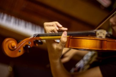 Genç bir kemancının bulanık sol eli kemanın tellerine basar, yatay olarak.