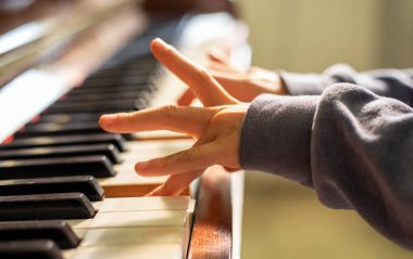 Küçük piyanistin elleri yatay olarak piyano çalmayı öğrenir.,