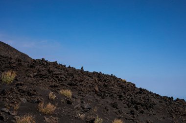 Soil from frozen lava on the Etna volcano against the sky