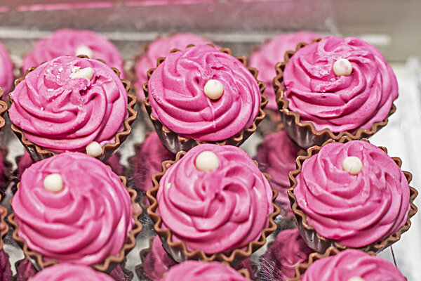 German chocolate-covered milk chocolates with pink fondant on top.