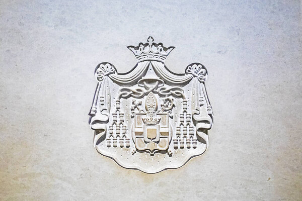 классический барельефный герб, вырезанный на каменных стенах собора.