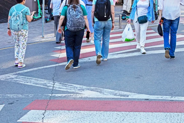 Gün boyunca büyük bir şehirde yaya geçidinde yayalar.