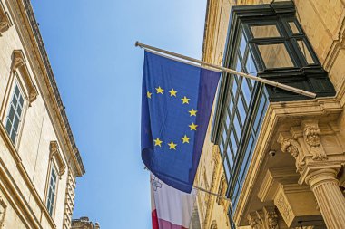 Bayrak direğinde Malta bayrağı, gökyüzüne karşı NATO bayrağı. Avrupa 'da seyahat
