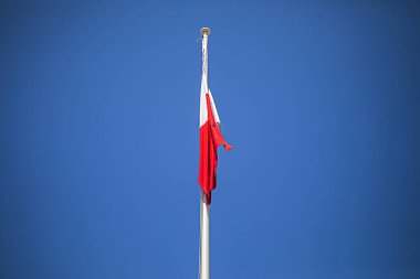 Mavi gökyüzüne karşı bayrak direğinde Malta bayrağı