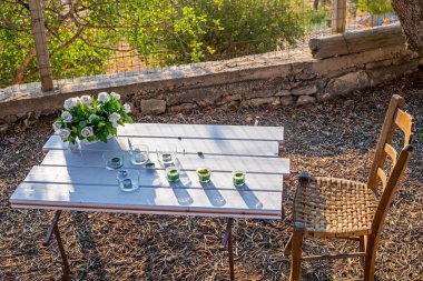 Güneşli bir sabah masasında şamdanlı beyaz güller. Meditasyon doğaya daha yakın.