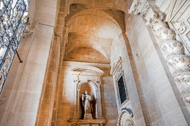 Kilisenin içinde mermer bir heykel ve işlenmiş demir pencere ızgaraları var.