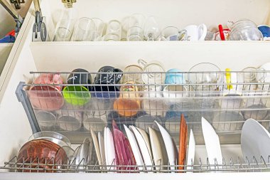 Tabaklar, bardaklar ve kaseler için rafları olan mutfak dolabı.