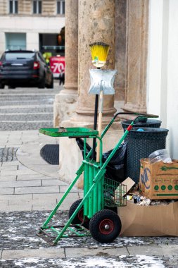 Şehir dışında çöp torbaları ve çöp tenekesi olan bir süpürge. Çevre koruma