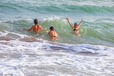 Fırtınada dalgalarda yüzen genç çocuklar. Denizde iyi tatiller..