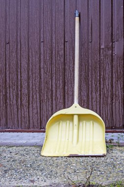 Yağmurlu havada demir bir kapının yanında büyük bir kepçe. Sezon başı.