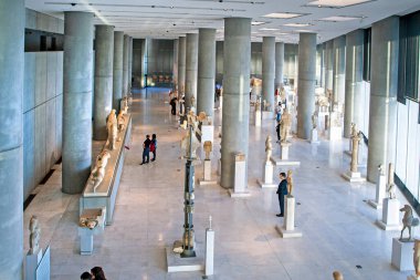 Atina müzelerinde ziyaretçilerin bulunduğu antik heykellerle dolu büyük, parlak bir iç mekan.