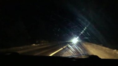 Geceleri sana doğru gelen kör edici farların olduğu karlı bir yol. Görüş mesafesi düşük.