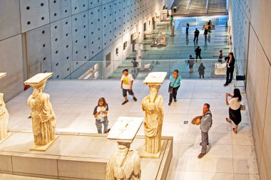 Atina 'daki Arkeoloji Seramik Müzesi' nde antik Yunan heykelleri ve ziyaretçilerle iç içe