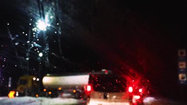 Karlı, kaygan bir yola sapmış bir kamyon karanlıkta trafik sıkışıklığı yaratıyor. Sürücü Güvenliği.