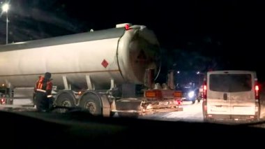 Karanlıkta kaygan bir yola sapmış bir kamyon otoyolda trafik sıkışıklığı yaratıyor.