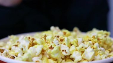 Sinemada galayı beklerken patlamış mısır yemek. Tatil ve okul tatili