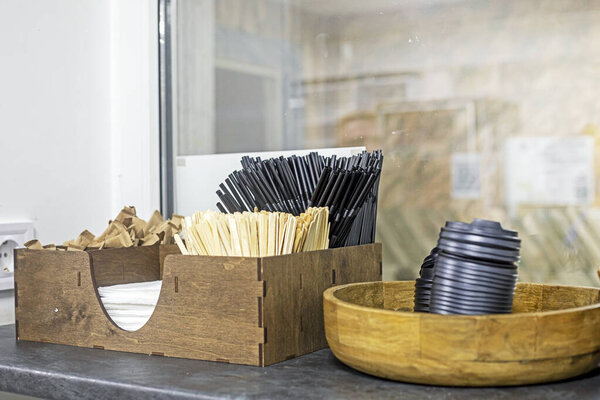 Disposable straws, cup lids, sticks, and sugar packets in the cafe at the entrance