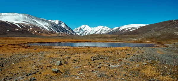 Snowy mountains reflected in lake