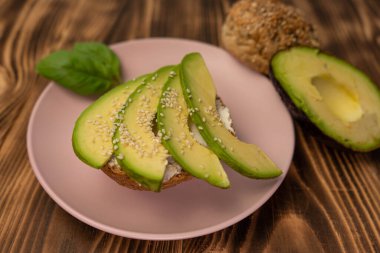 Sağlıklı vejetaryen organik kahvaltı sandviçi kuşkonmaz, avokado, salatalık, tam tahıllı çöreğin üzerine yumuşak peynir. Tahta, tahtayı kapat.