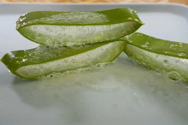 Aloe Vera beyaz tabakta meyve suyu ile doğruyor, yakın çekim su deri bakım spa 'sını düşürüyor