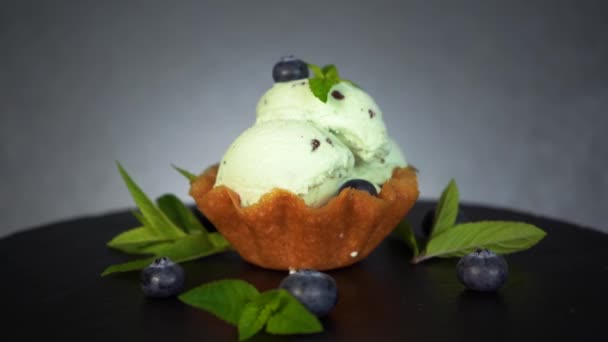 Derretimiento de helado de menta chocolate mordeduras de arándano decorado postre waffle, 4K — Vídeo de stock