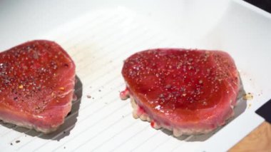 Eller beyaz tavada ton balığı bifteğini çatal ve ahşap spatulayla çevirir, 4K