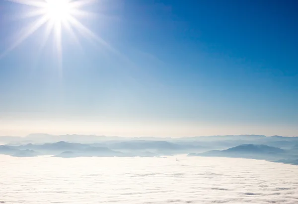 View on mountains and sun above clouds