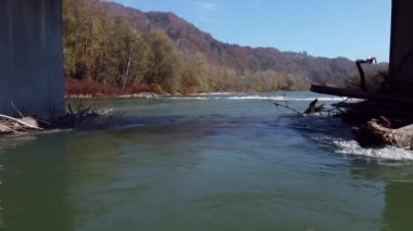 dalgalı nehir köprünün altında suyla uçuyor.