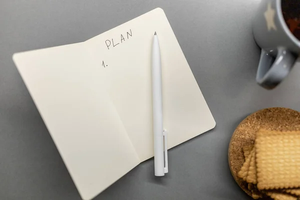 Abrir la galleta de la taza del cuaderno y pluma en la mesa gris —  Fotos de Stock