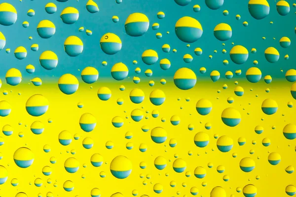 Water drops above ukrainian flag — Stock Photo, Image