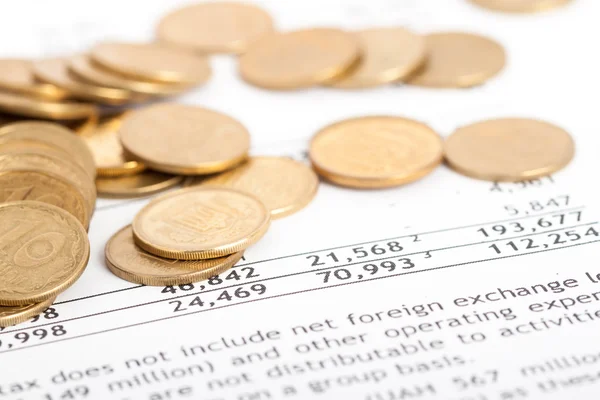 Coins laid out on document — Stock Photo, Image