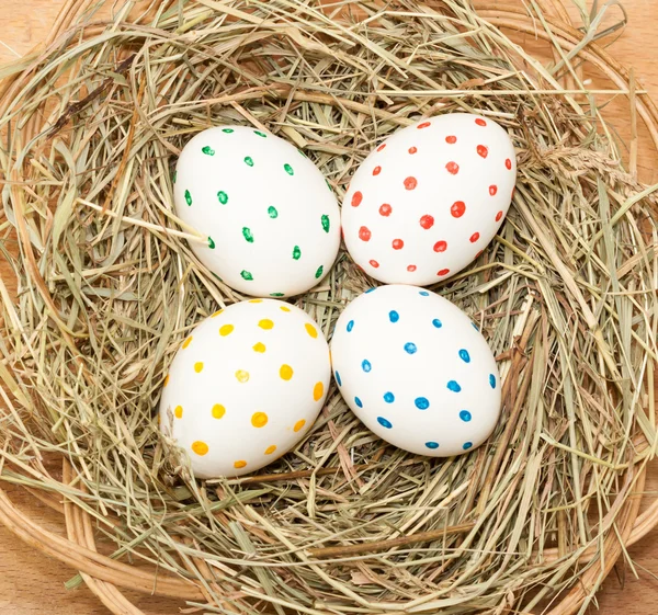 Vier gespot gekleurde Pasen eieren in het hooi — Stockfoto